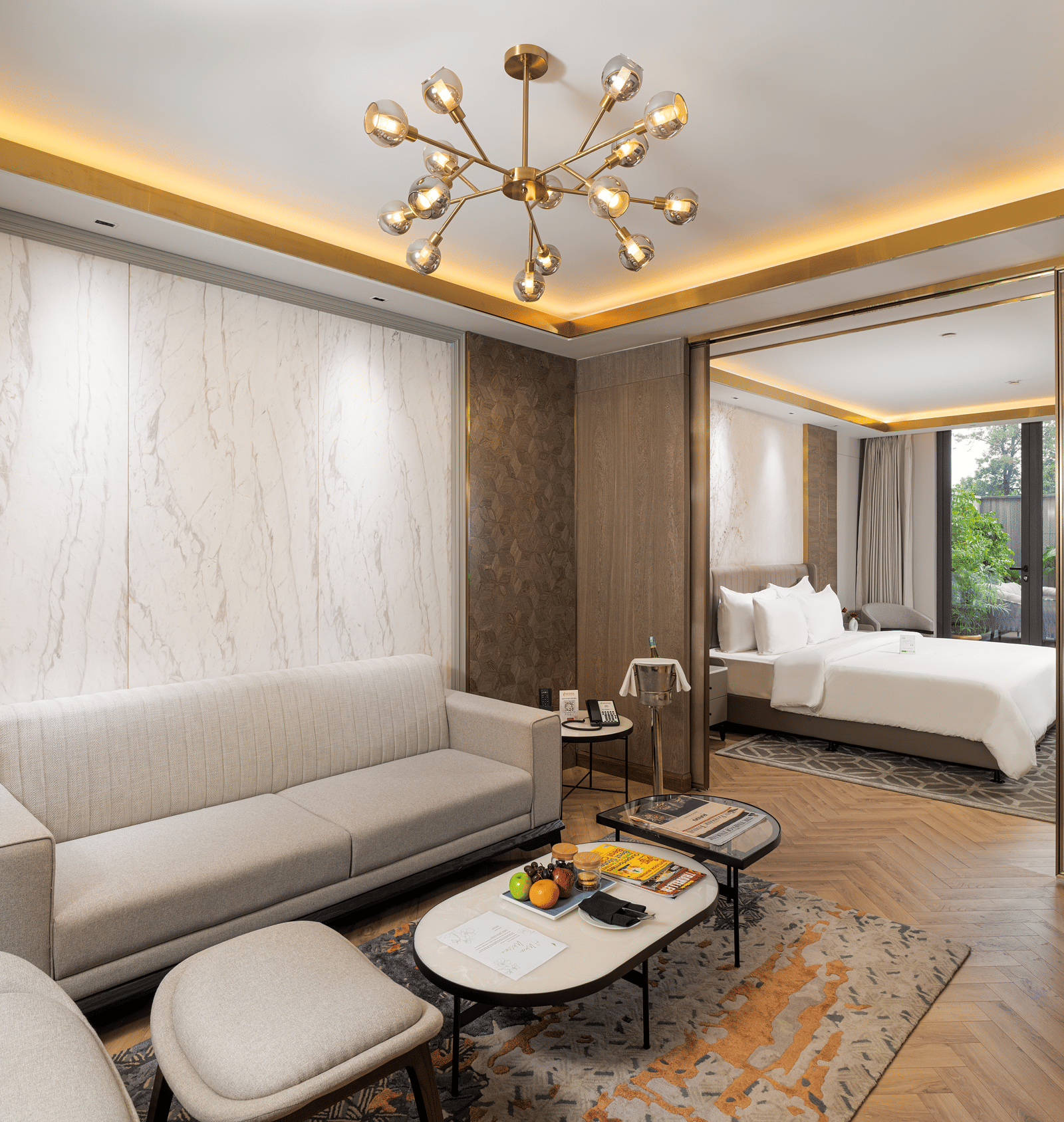 Nirvana Suite living area with a stylish sofa, a chic coffee table, and an open view into the spacious bedroom - Nirvana Luxury Hotel, Ludhiana