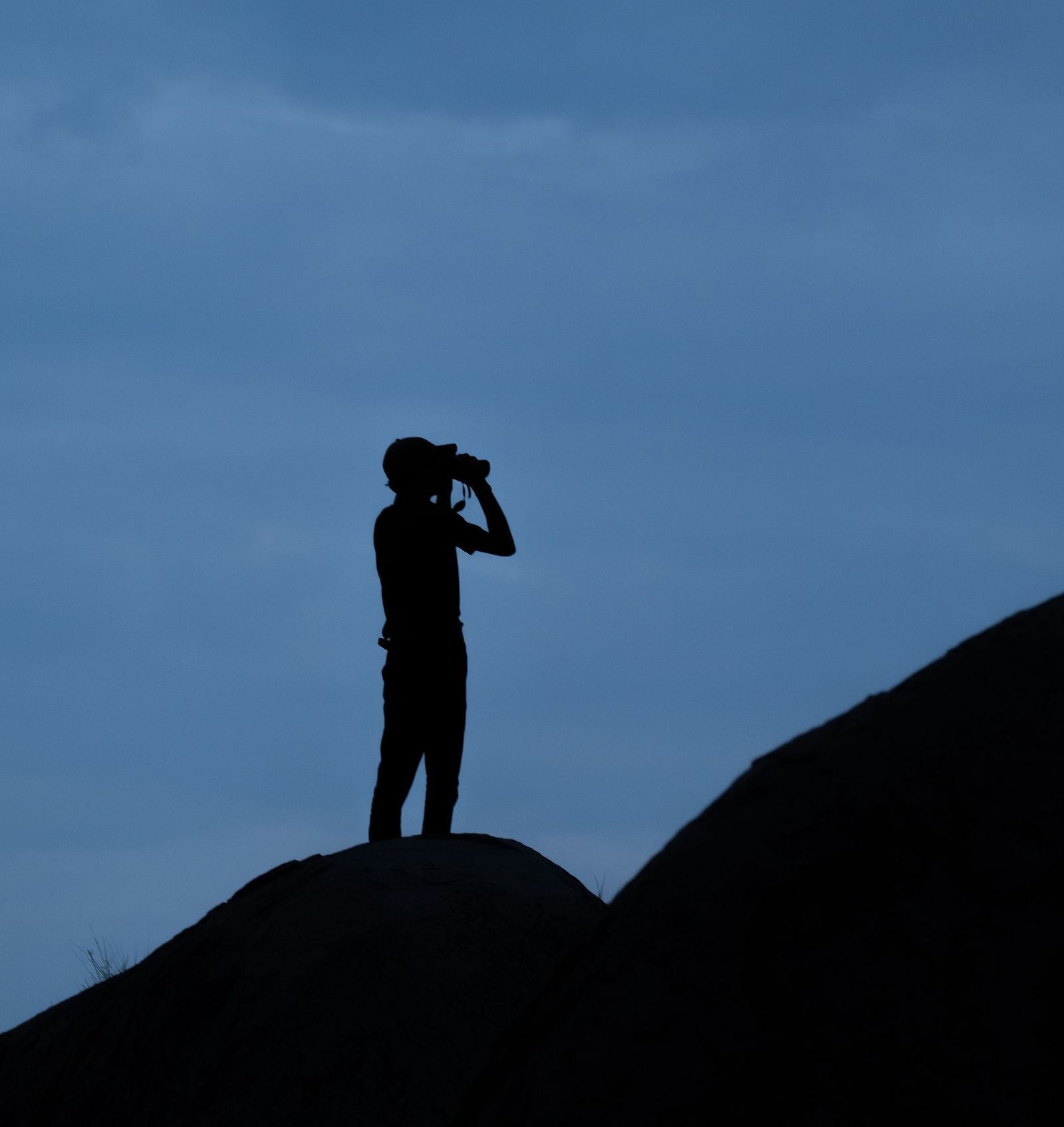A person using a binoculars on top of a mountain - Utsav Camp