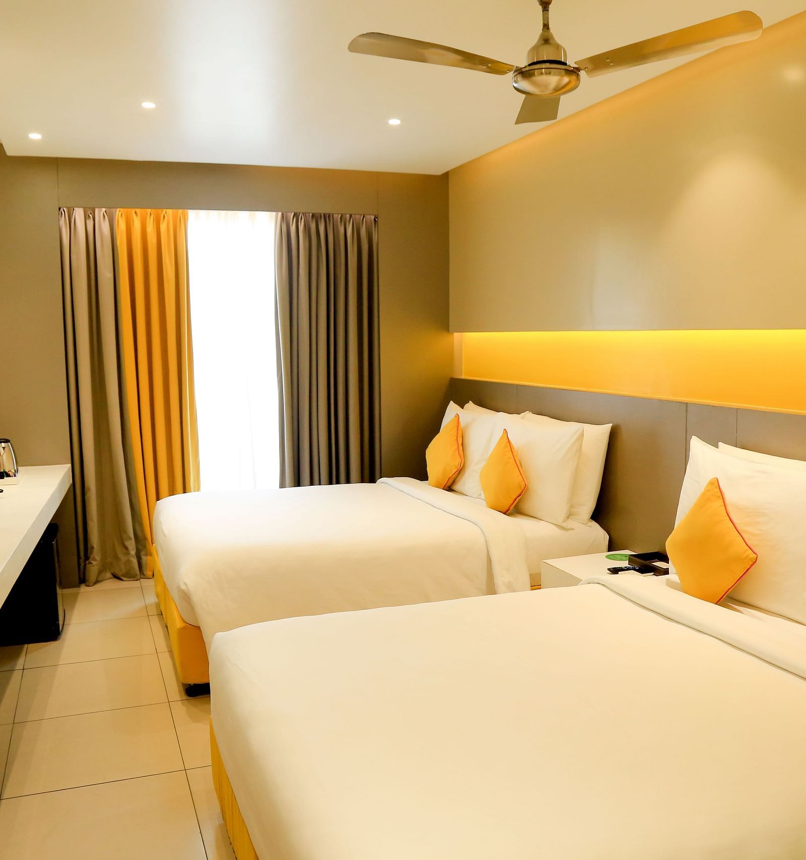  Spacious twin beds with headboards line the wall, large windows with curtains cover them