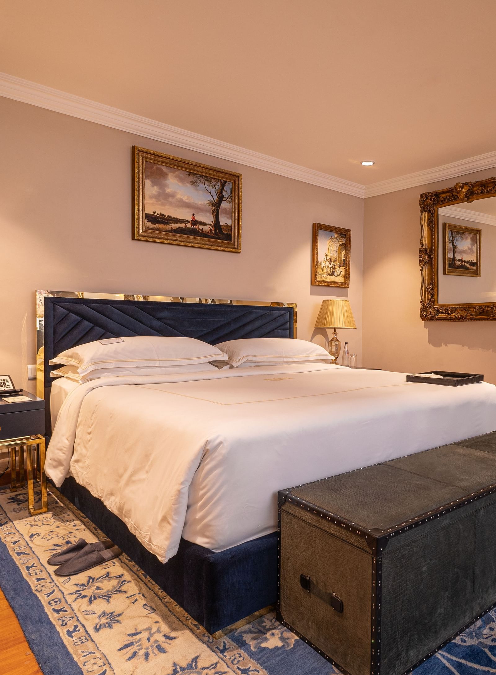image of the bedroom with a soft comfortable bed with a wooden trunk in front of the bed at our regent suites - The Claridges New Delhi