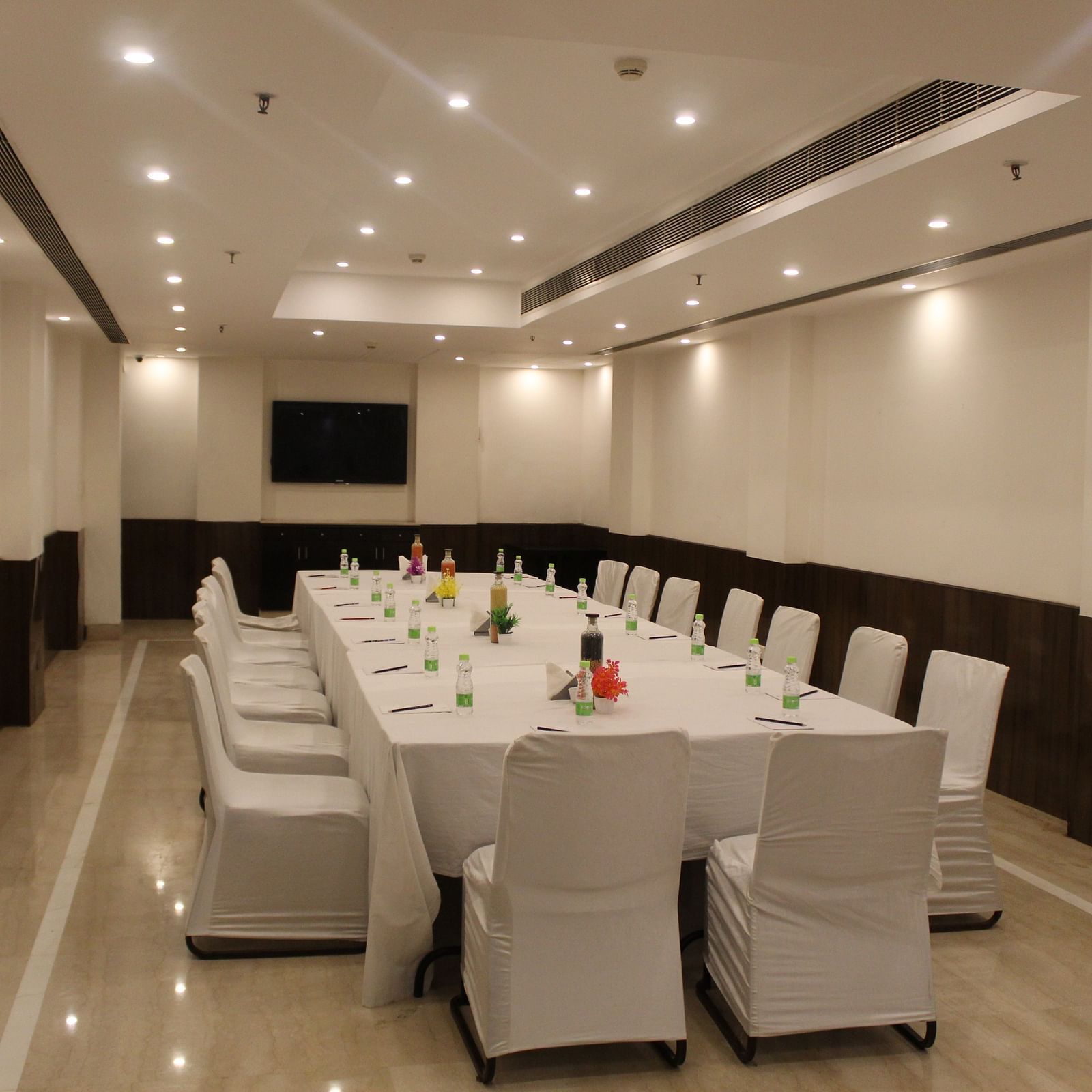 An image of a conference room at Inde Hotels Vista Woods featuring a huge table surrounded by several chairs