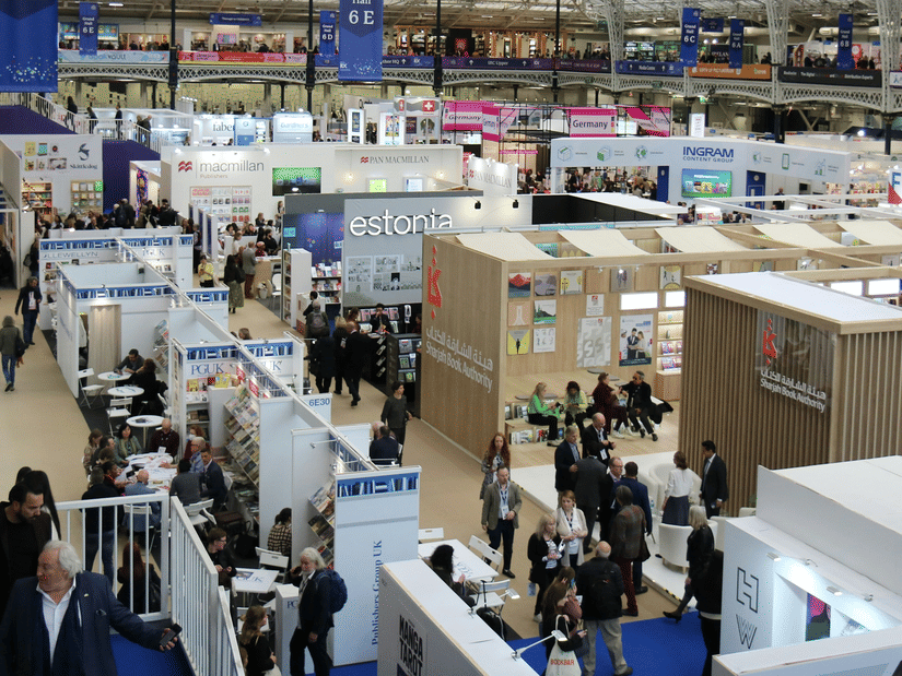 Large indoor exhibition hall featuring multiple display booths, business exhibitors, and visitors exploring the venue.