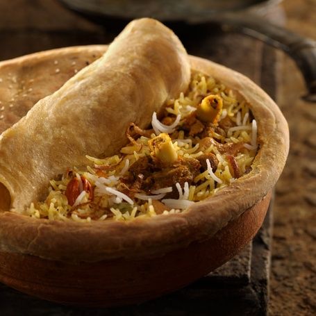 Biryani in a clay pot with a bread seal.