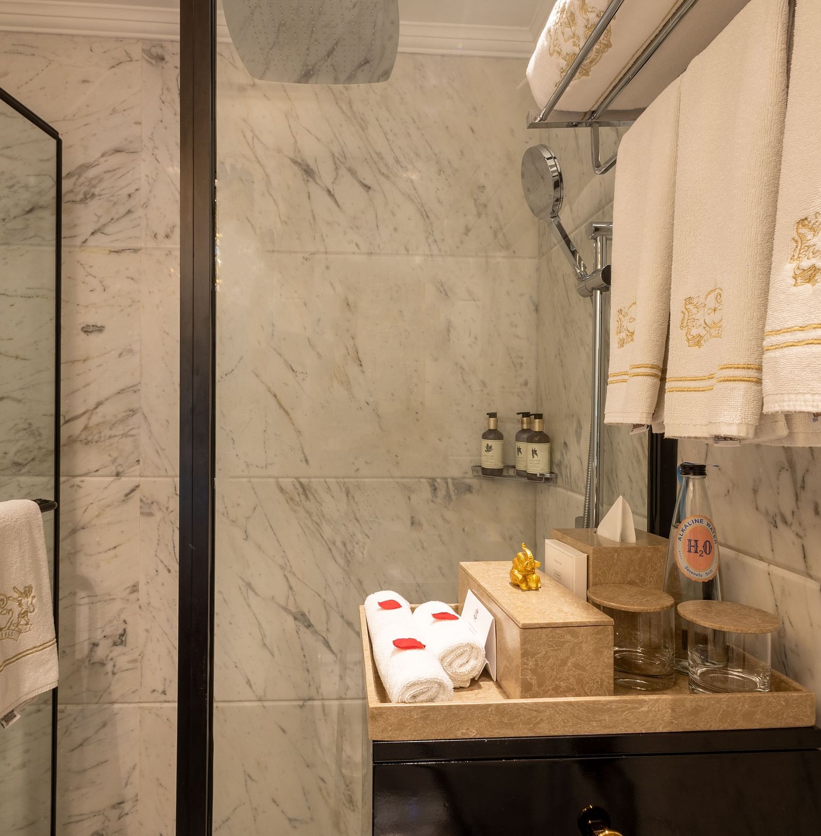 Washroom of the Luxury King Bed Room with Balcony at The Claridges New Delhi, featuring a glass door and neatly hung towels