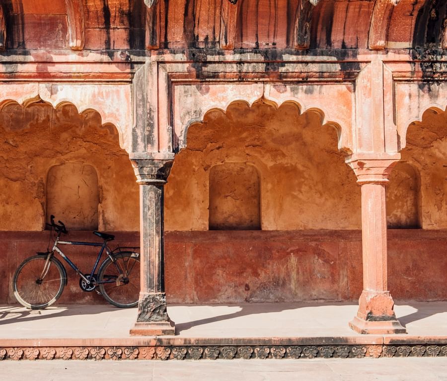 Bicycles are parked inside an Indian building with Islamic style architecture