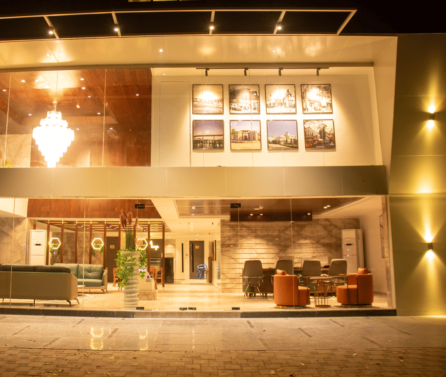 The exterior view of illuminated hotel entrance and glass facade at Magnus Lxia Premier, Kalyani Nagar.