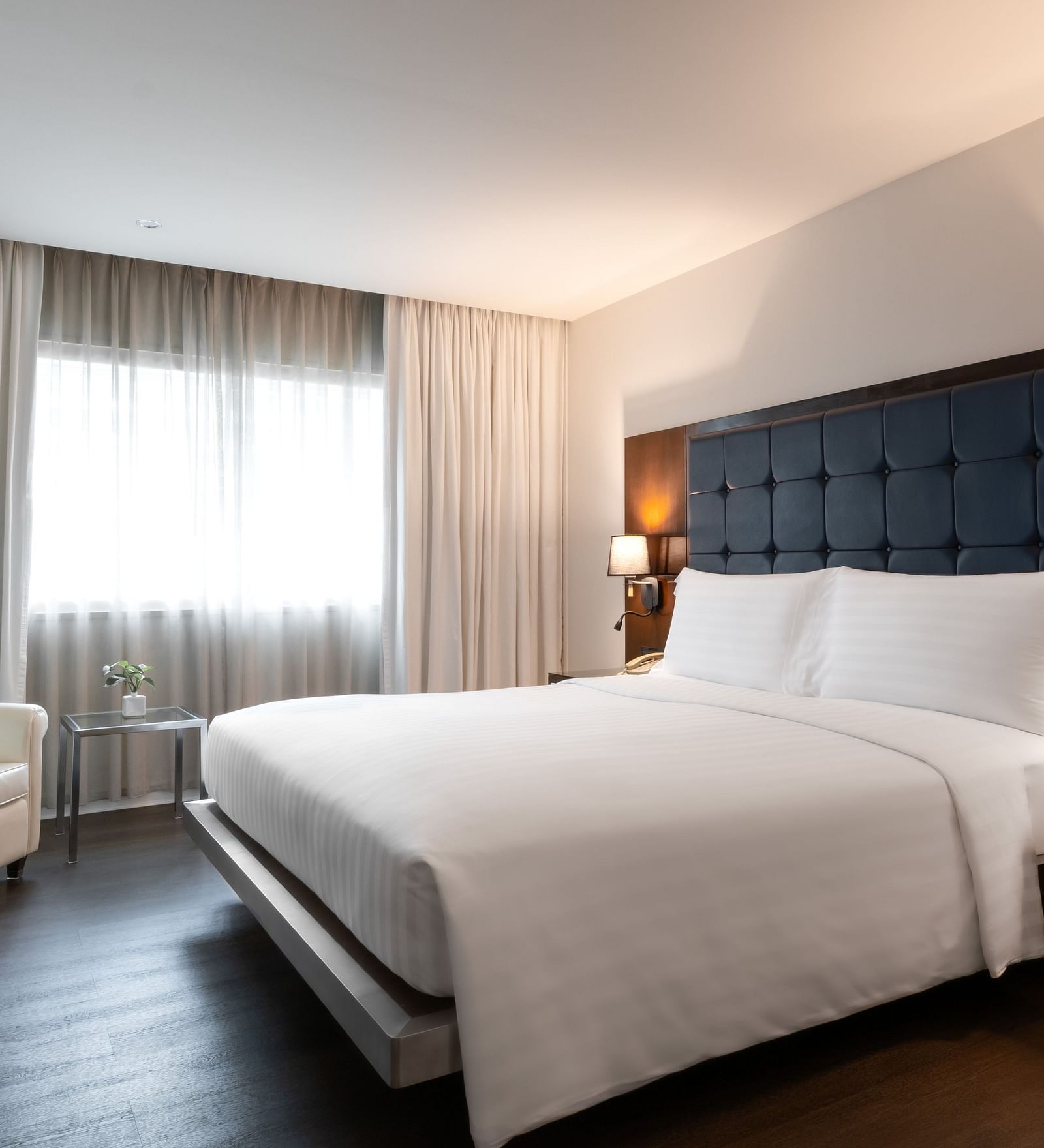An overview of a double bed with lamps on the side inside one of the rooms - Night Hotel Bangkok