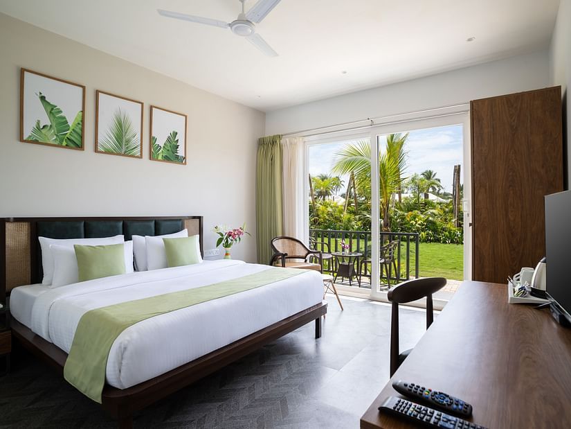 full view image of the premium cottage at sibaya beach resort in morjim beach, goa featuring a lush green scenic view from the huge windows in the room