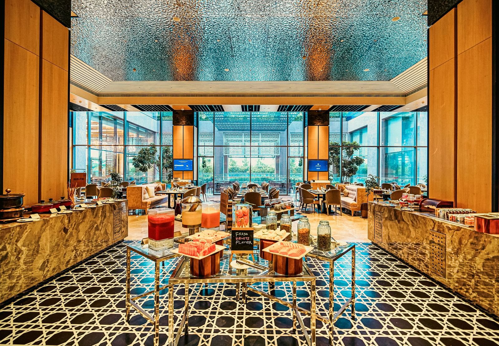 A vibrant buffet setup with fresh juices and fruit platters, framed by sleek and elegant decor