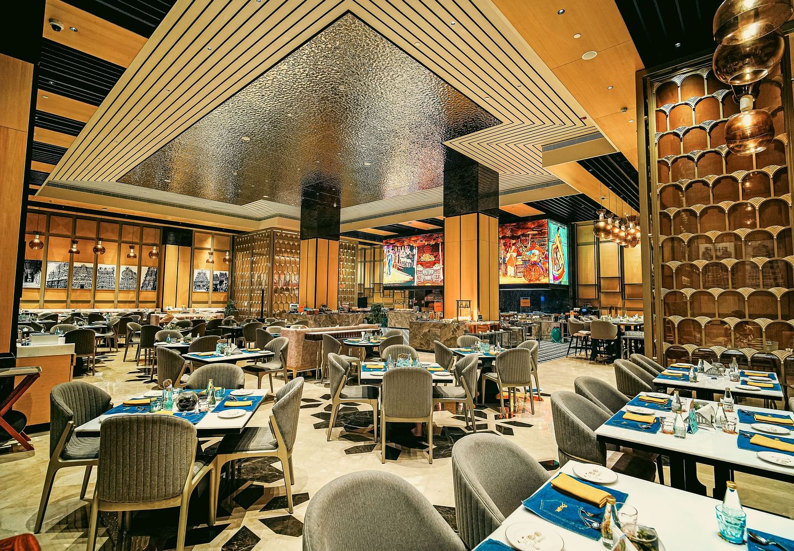 A wide view of the vibrant restaurant interior with elegant dining tables and unique ceiling design