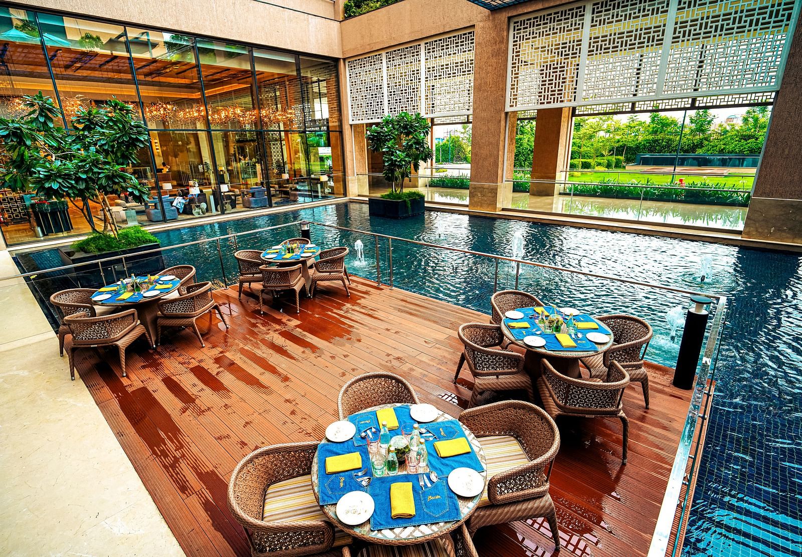 An alfresco dining space overlooking a reflective pool, surrounded by lush greenery