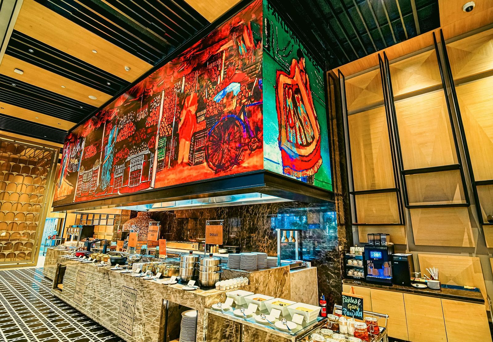 A colourful live station in the restaurant featuring artistic murals and a wide selection of food