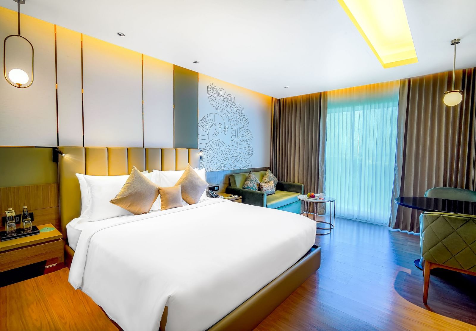 An image of our Business Class Room in Madurai with a large bed, hanging lamps. a night stand and a work desk