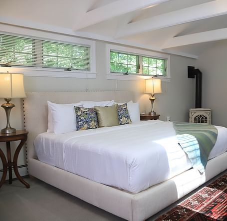 Spacious bedroom with white bed and beams at Hartstone Inn