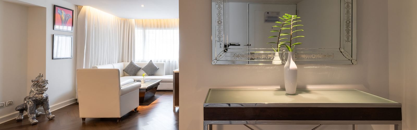 An overview of a room with a table having a vase and a mirror on the wall - Night Hotel Bangkok.