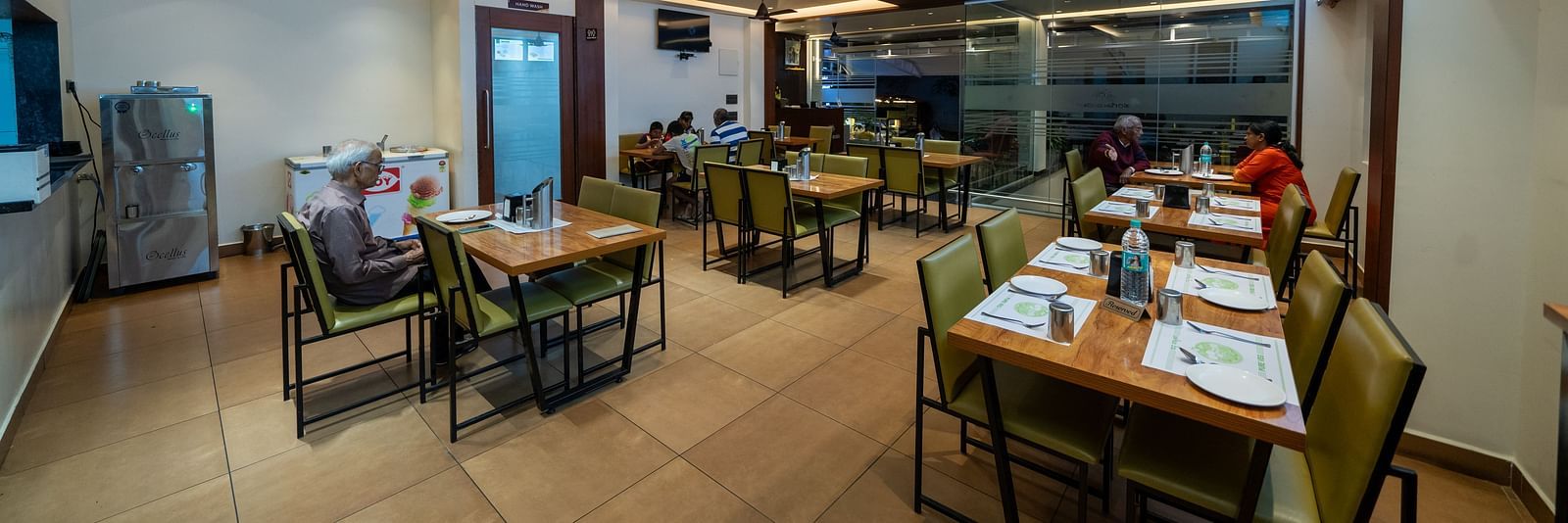 Full view of the dining area at Hari Govinda's, with all tables and chairs neatly set and bright lighting illuminating the space