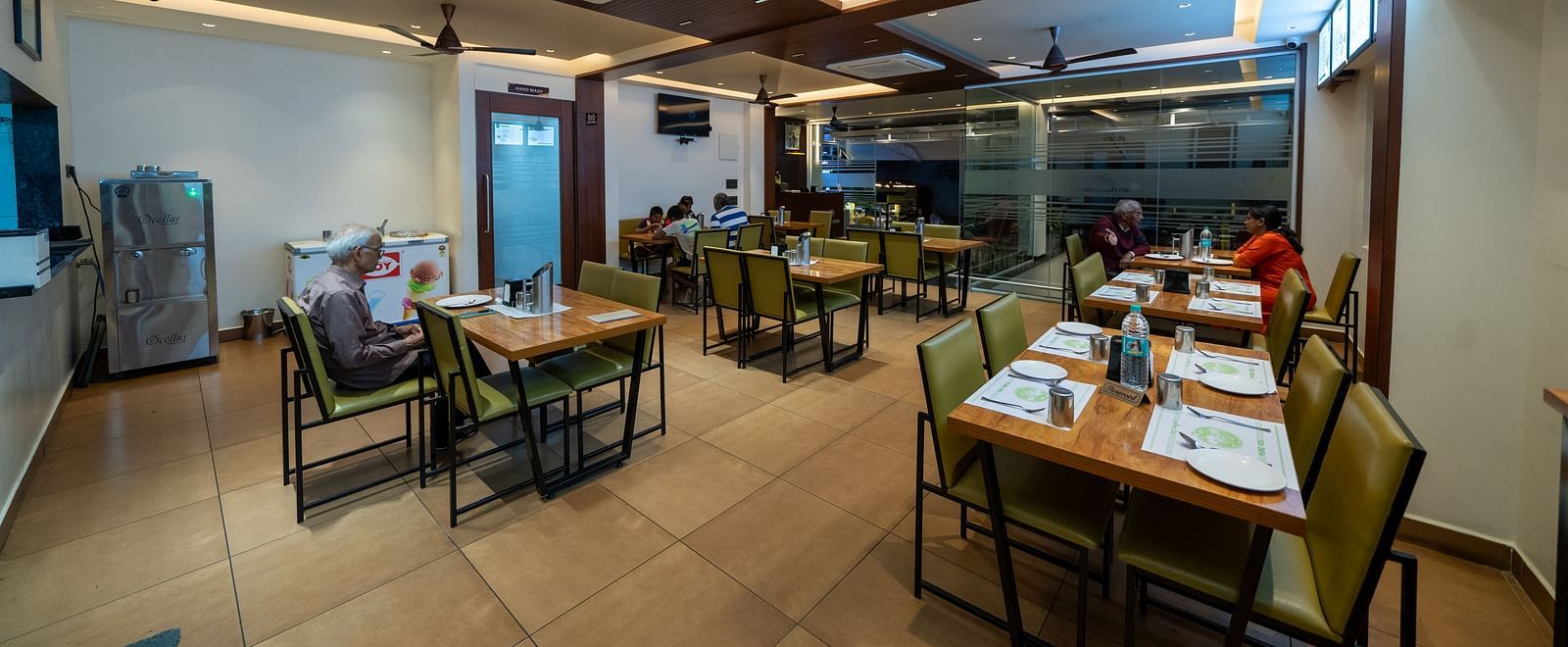 Full view of the dining area at Hari Govinda's, with all tables and chairs neatly set and bright lighting illuminating the space