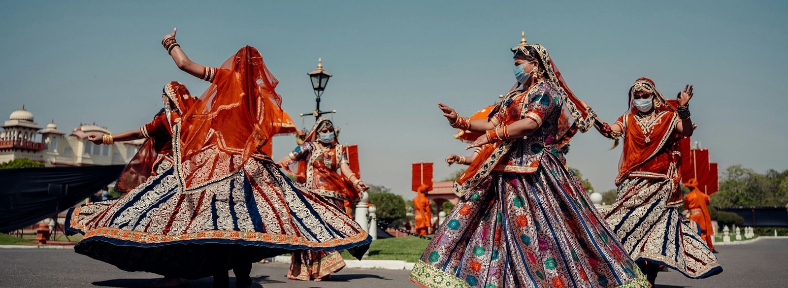 Three women in traditional Rajasthani attire performing a dance.
