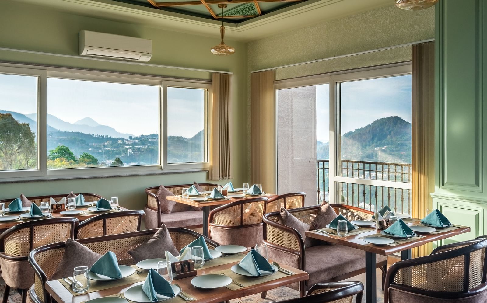an image of a dining space filled with natural light, chairs and tables are placed with cutlery and hand towels at Mountoria Retreat, Naukuchiatal