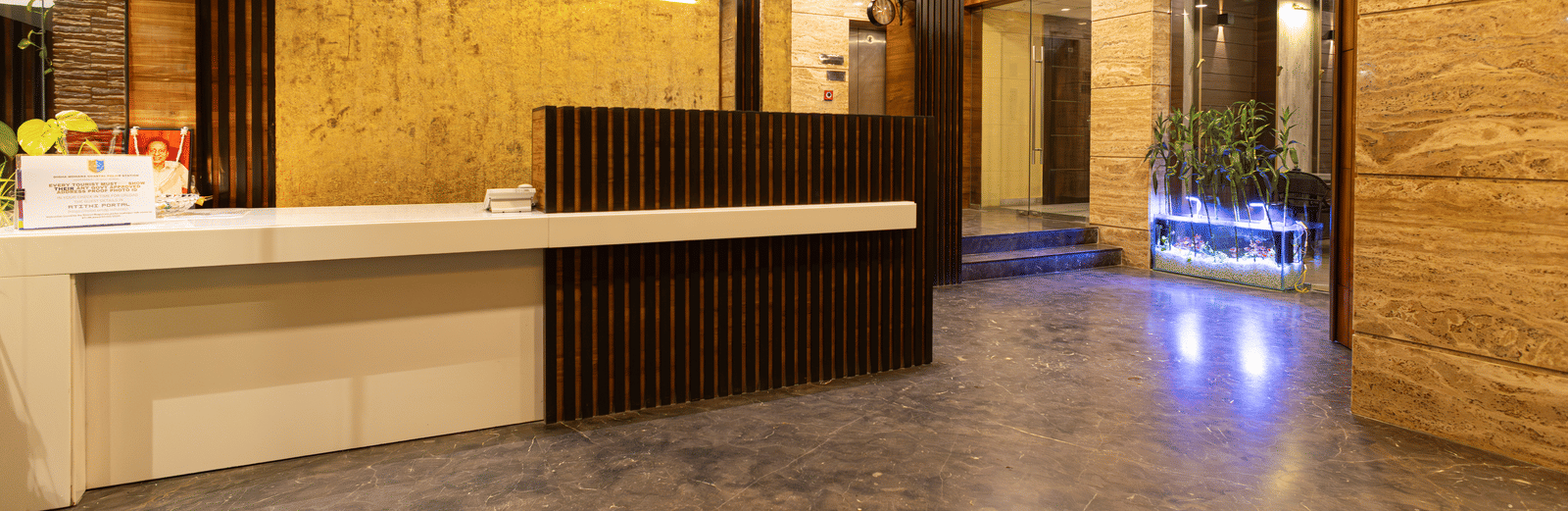 Spacious hotel lobby interior with a sleek wooden reception desk and warm lighting - Hotel Seagull Digha