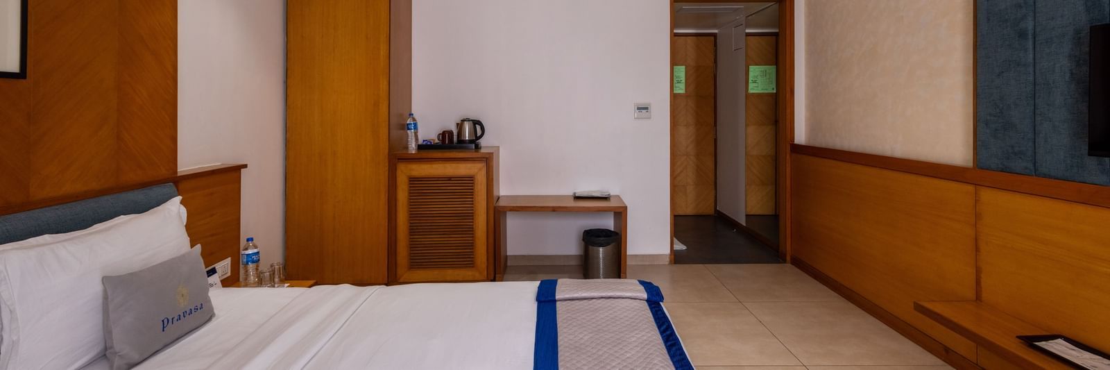 Side view of the bed, wardrobe, desk, and entryway to Executive Premium Room at Pravasa Stay Vijay Nagar, Indore.