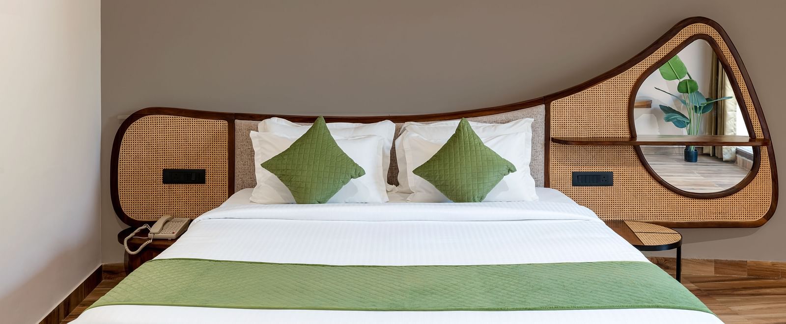 Luxury Villa with Sitout  featuring a close-up view of a king size bed with a wooden headboard, green and white bedding, and a decorative mirror on the wall at The Qualia Resort Club & Brewery, Udaipur.