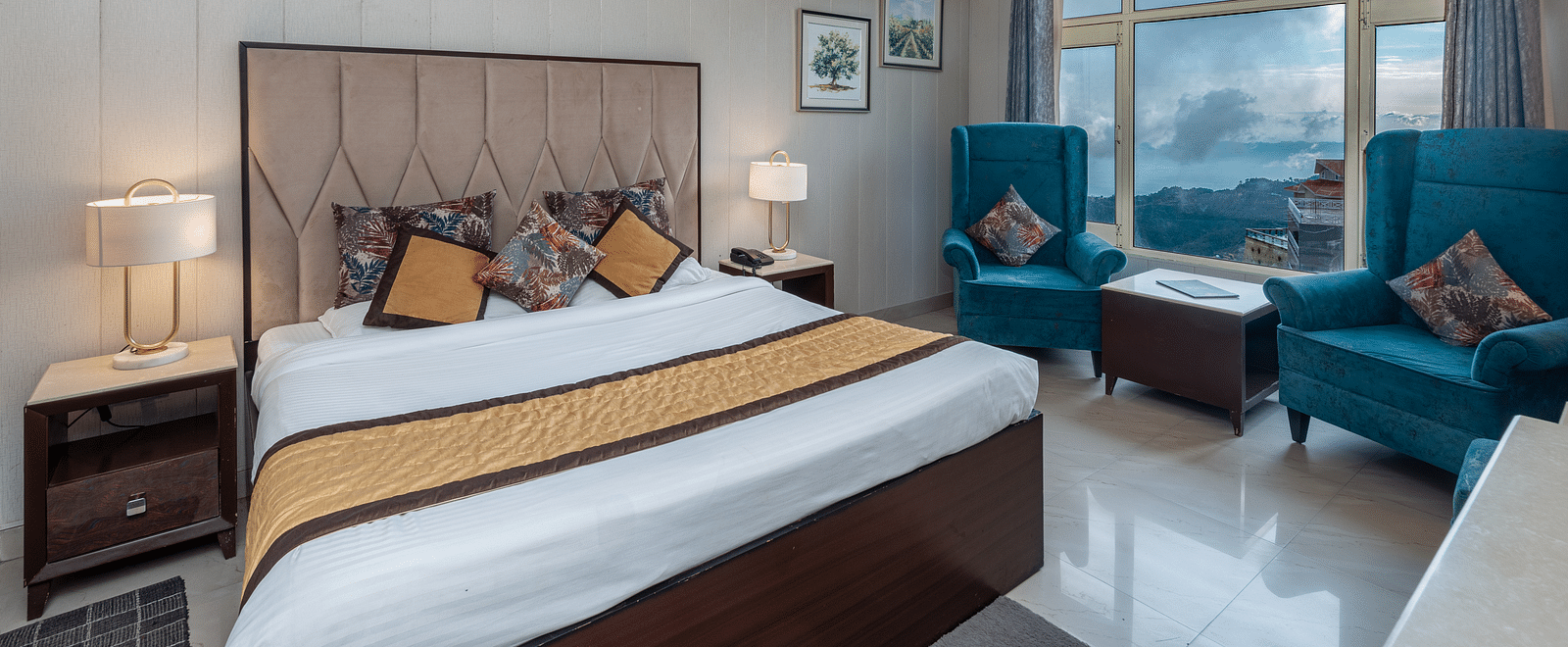 Shot on a well furnished room featuring a king size bed and a large window with two chairs placed near the window | DLS The Pearl