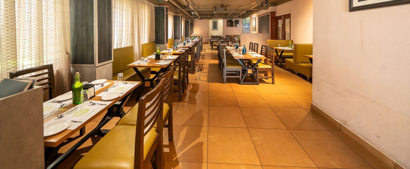 Image of a dining area with a photo frame mounted on the wall on the side at Hari Govindas, Siddappa Square.
