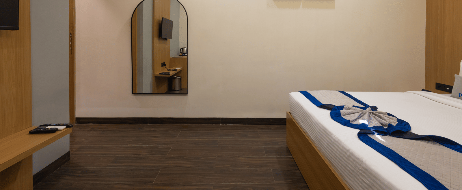 Interior of a guest room showing the bed, mirror, and wall art at Pravasa Stay Luv Kush, Indore.