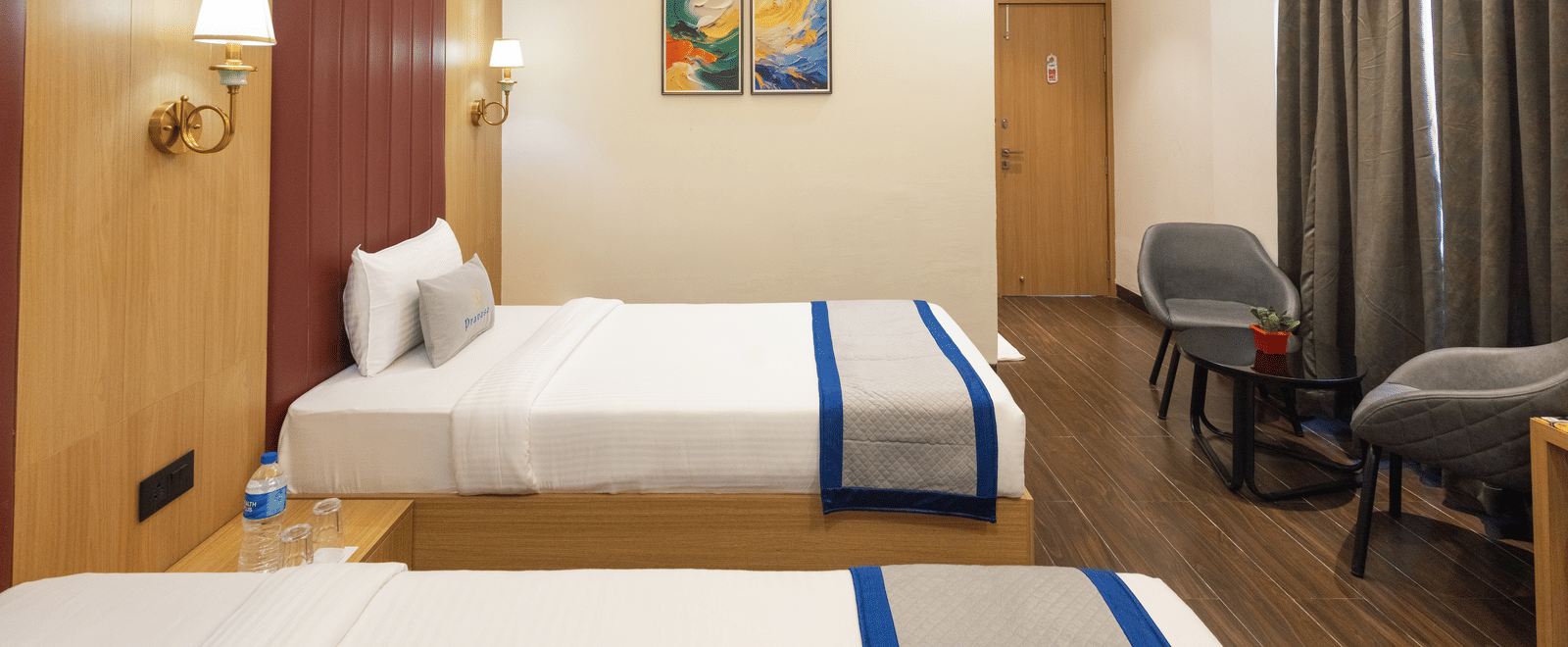 Interior view of a guest room with 2 single beds and seating at Pravasa Stay Luv Kush, Indore.