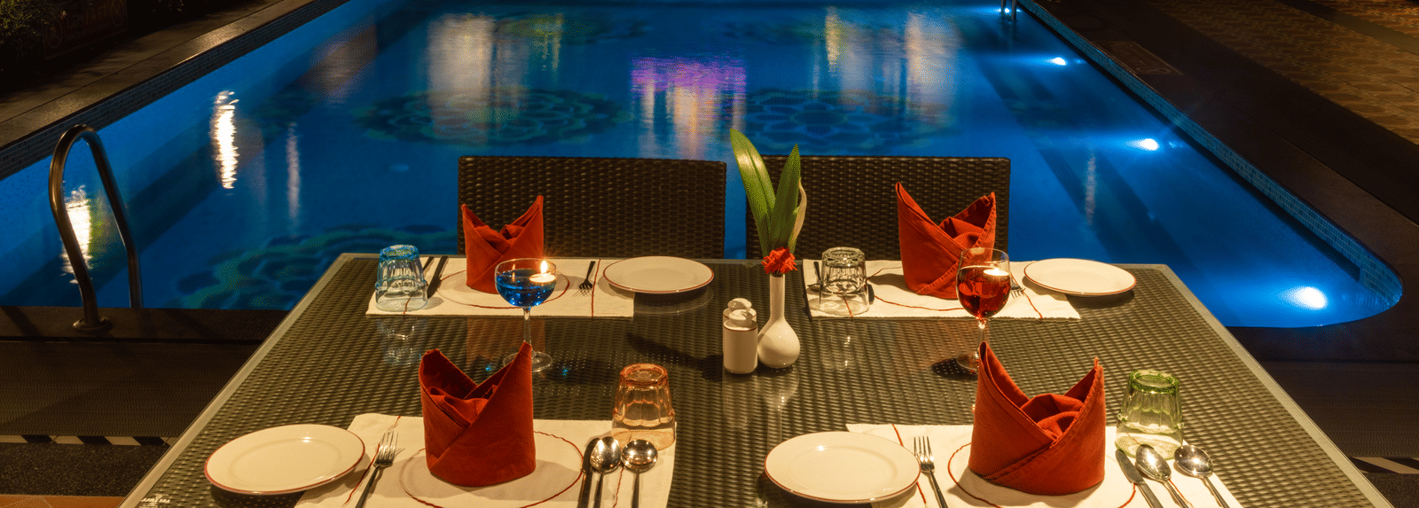 Tranquil pool with artistic tile design and lush greenery at dusk. Regency Madurai by GRT Hotels