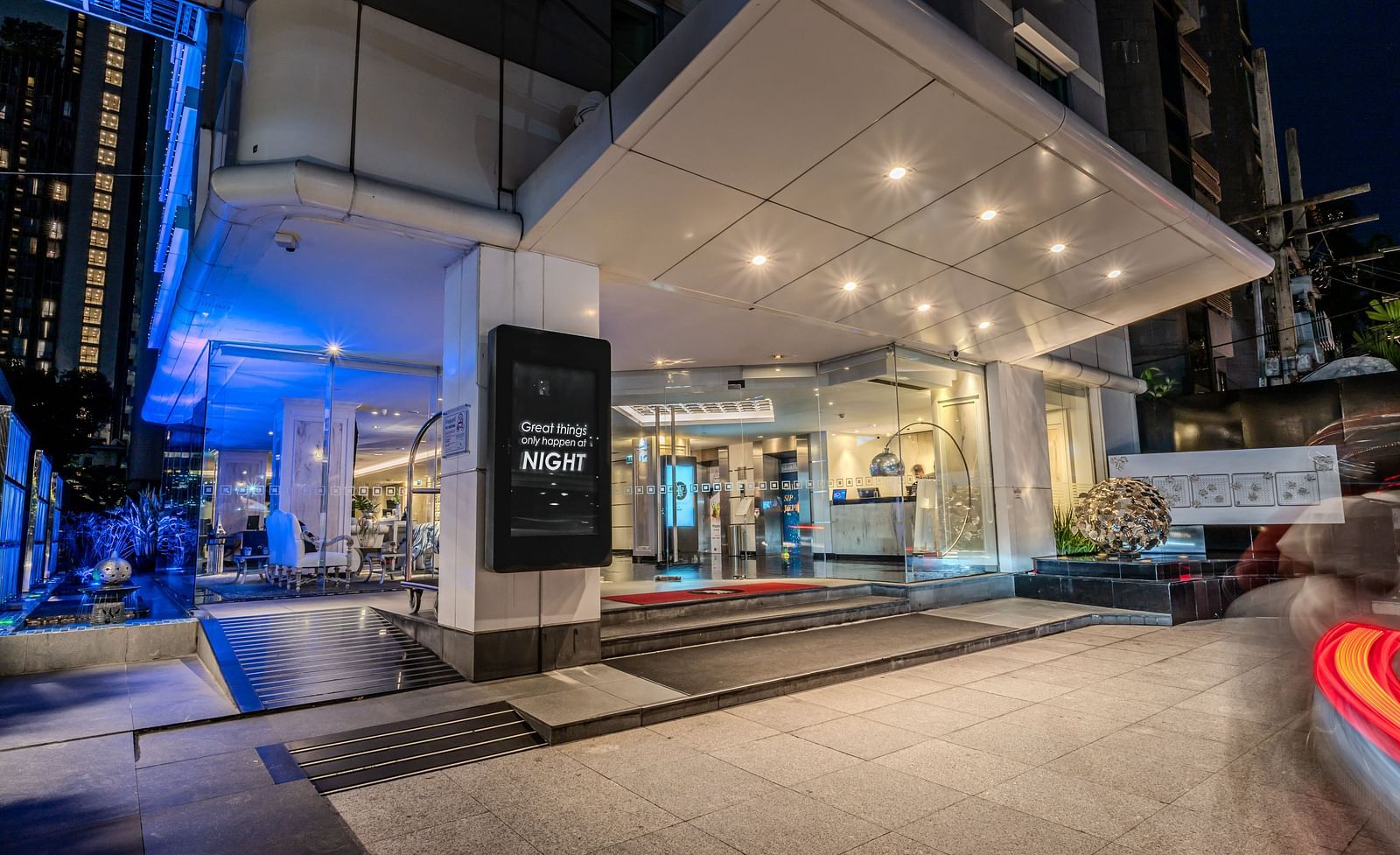The entrance of Night Hotel Bangkok during the night with the lights on.