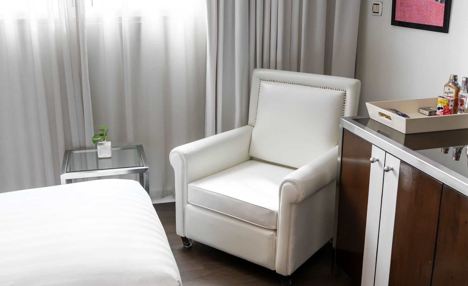 A close up shot of a chair next to a table inside one of the rooms - Night Hotel Bangkok.