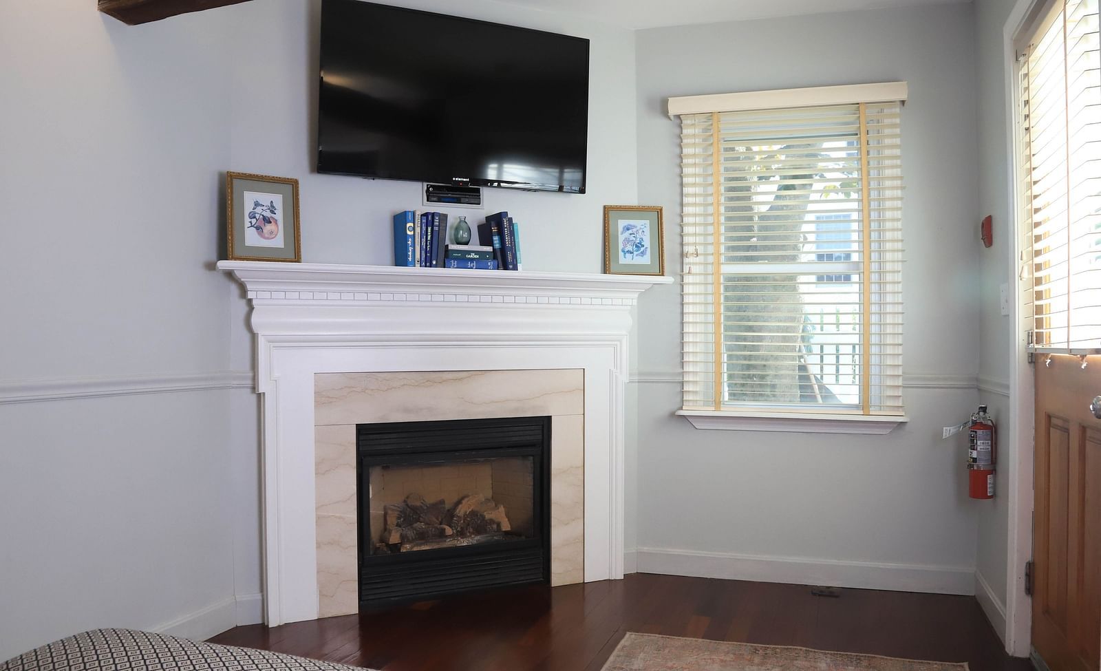 Room with a fireplace, TV, and window at Hartstone Inn.