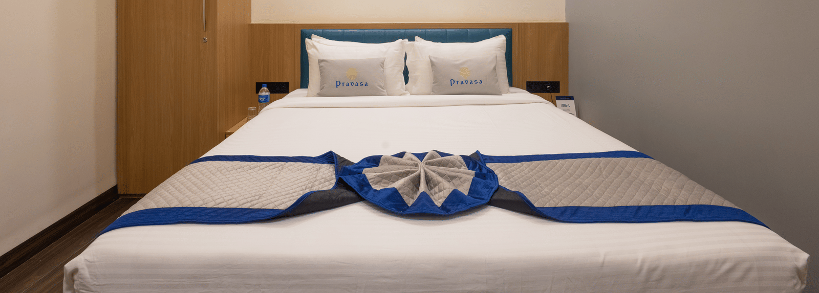 Interior of a guest room showing the bed and a full-length wooden cupboard at Pravasa Stay Luv Kush, Indore.