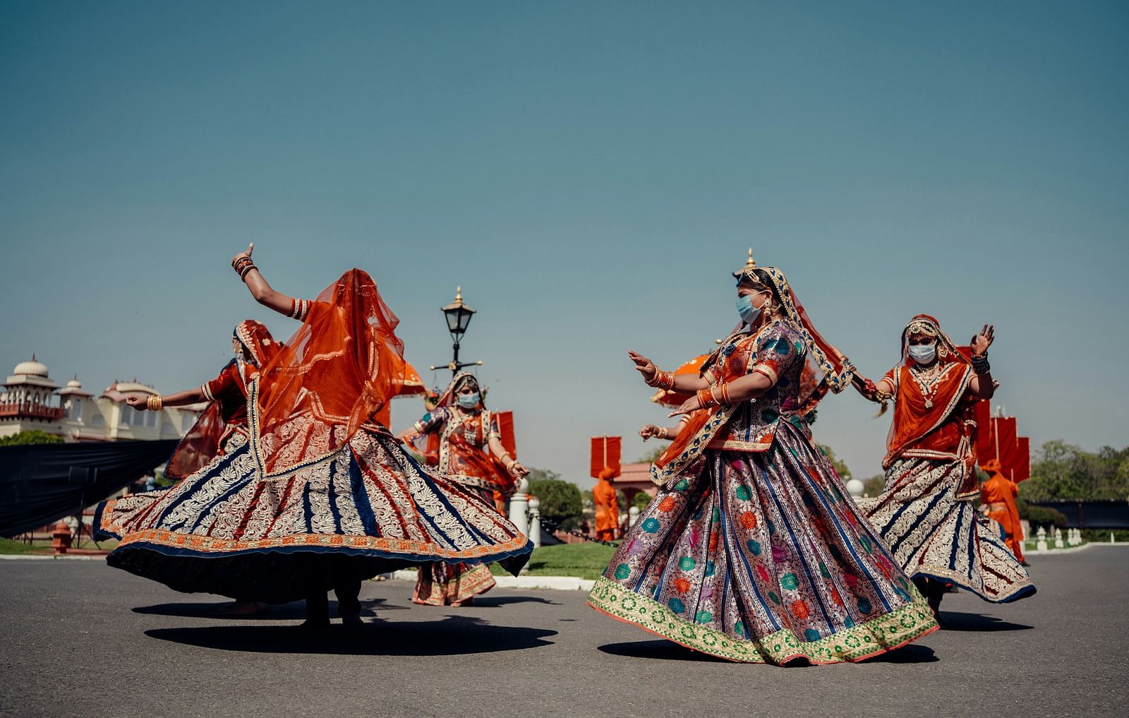 Three women in traditional Rajasthani attire performing a dance.