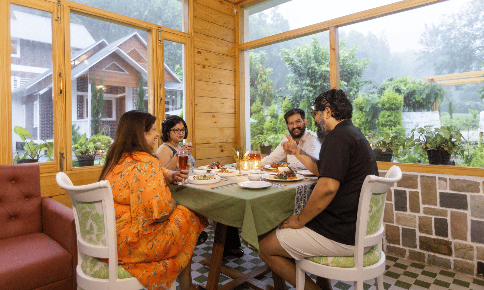 Guests enjoying a relaxed conversation over tea in a bright cafe - Megha Resort & Villas, Dehradun