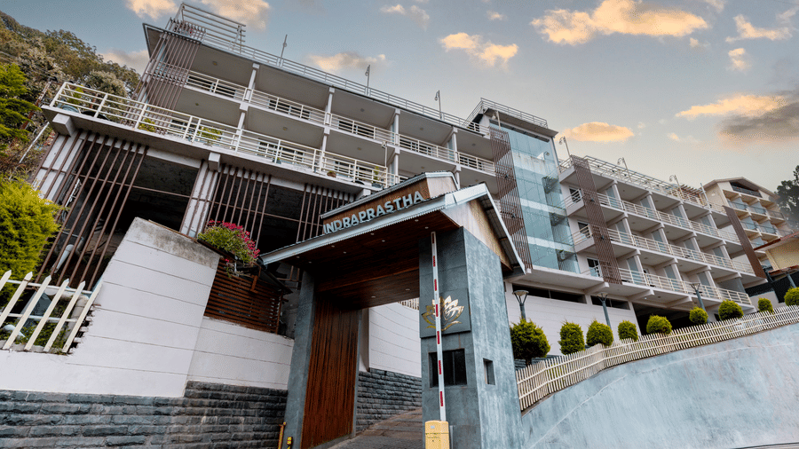 An exterior view of Indraprastha Resort & Spa, McLeod Ganj with multi-level building, entrance area, steps, and railings leading up.
