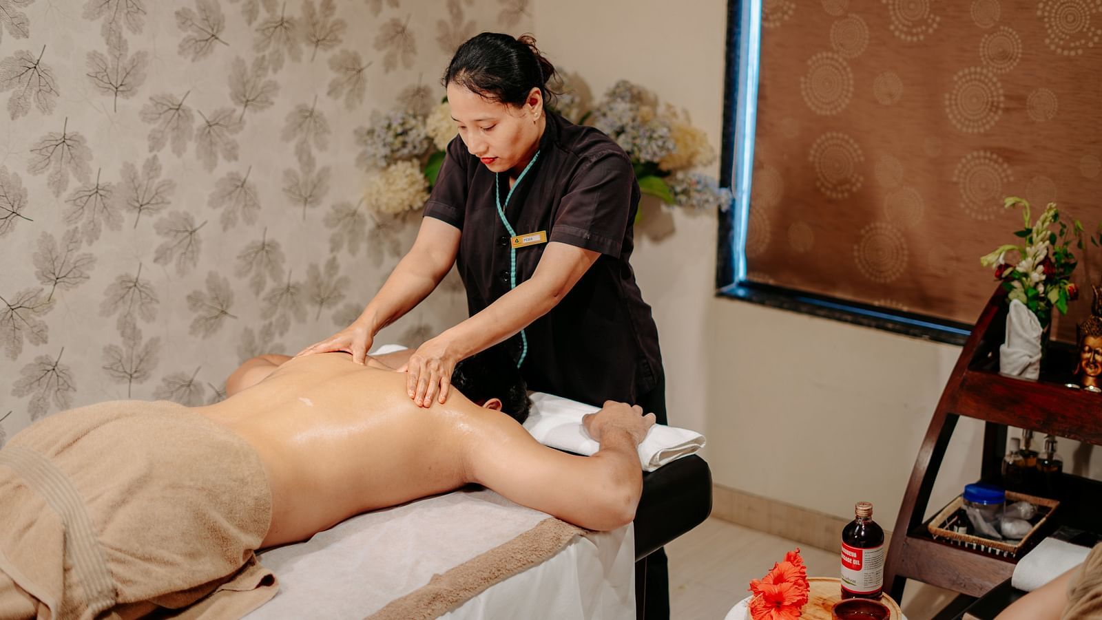 A woman providing a back and shoulder massage to a guest at Crescent Spa & Resort, Indore