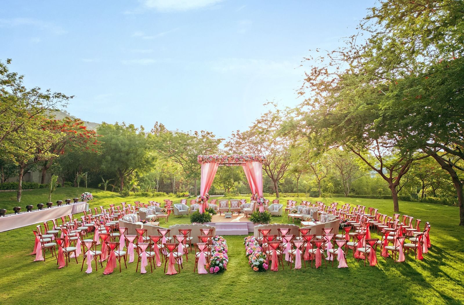 An elegant setting of chairs facing towards the stage in a lawn on a sunny day at Essentia Luxury Resort & Spa, Udaipur. 