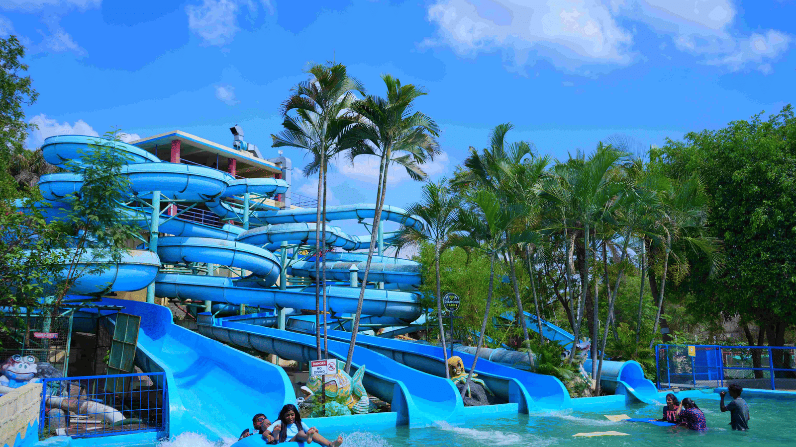 An overview of a spiral water slide with many people sliding down inside the waterpark at Diamond Parks, Pune - The Best Place for Photoshoot in Pune.