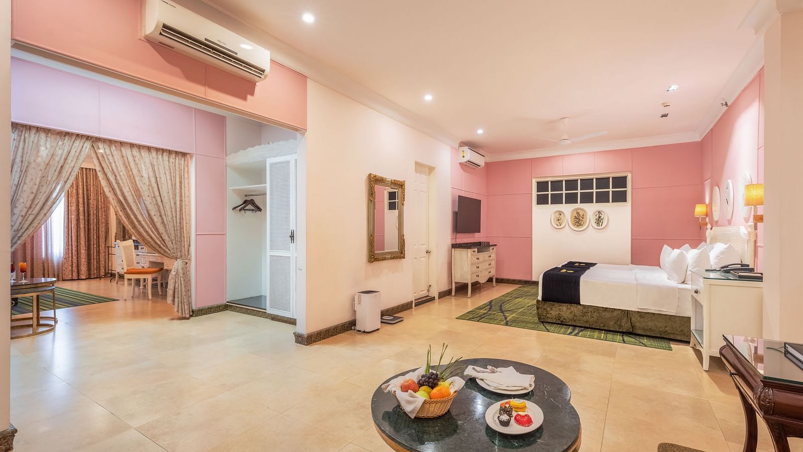 Spacious bedroom with storage unit, a seating area with a coffee table, a dressing table, and a separate living room at MAYFAIR Palm Beach Resort, Gopalpur-On-Sea