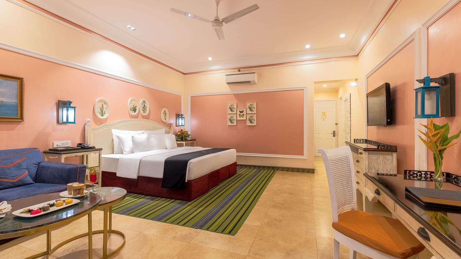 Spacious room with large bed, a seating area, a workstation, and a wall-mounted TV at MAYFAIR Palm Beach Resort, Gopalpur-On-Sea