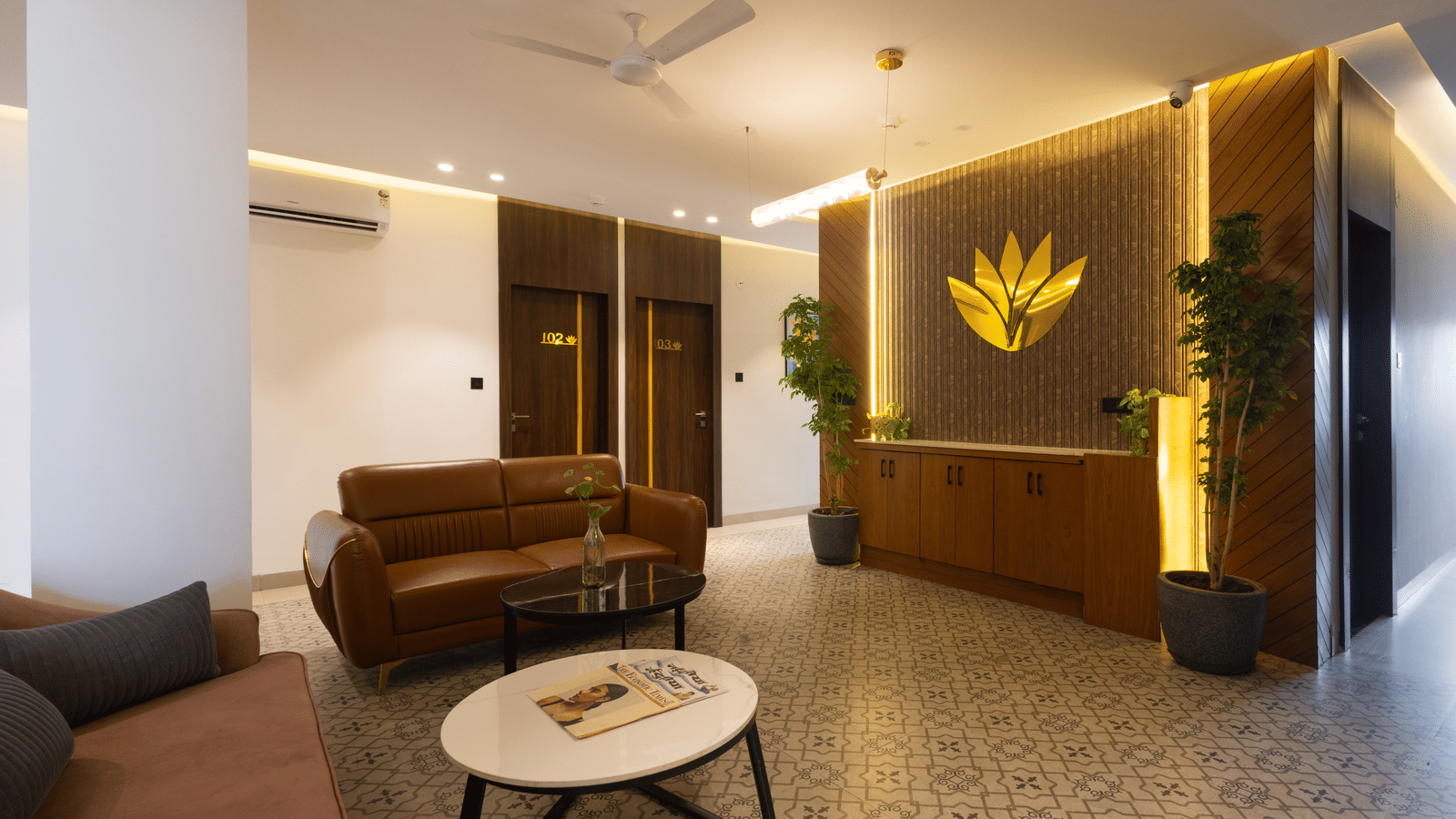Interior view of the lobby area with a brown sofa and a decorative logo on the wall at Pravasa Stay Luv Kush, Indore.
