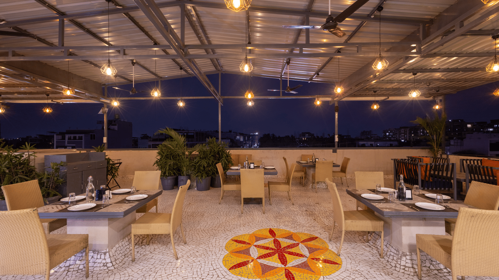 Exterior view of the rooftop terrace with tables and chairs at Pravasa Stay Luv Kush, Indore.
