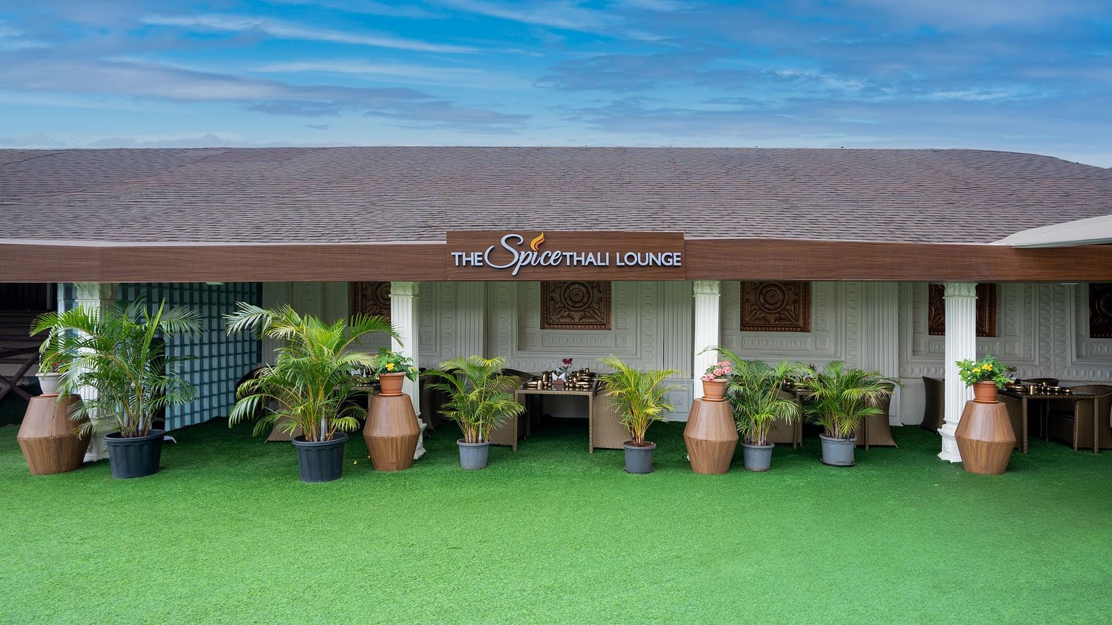 Shot of the exterior of spice lounge with a green law at the entrance |  The Grand Legacy Resort and Spa