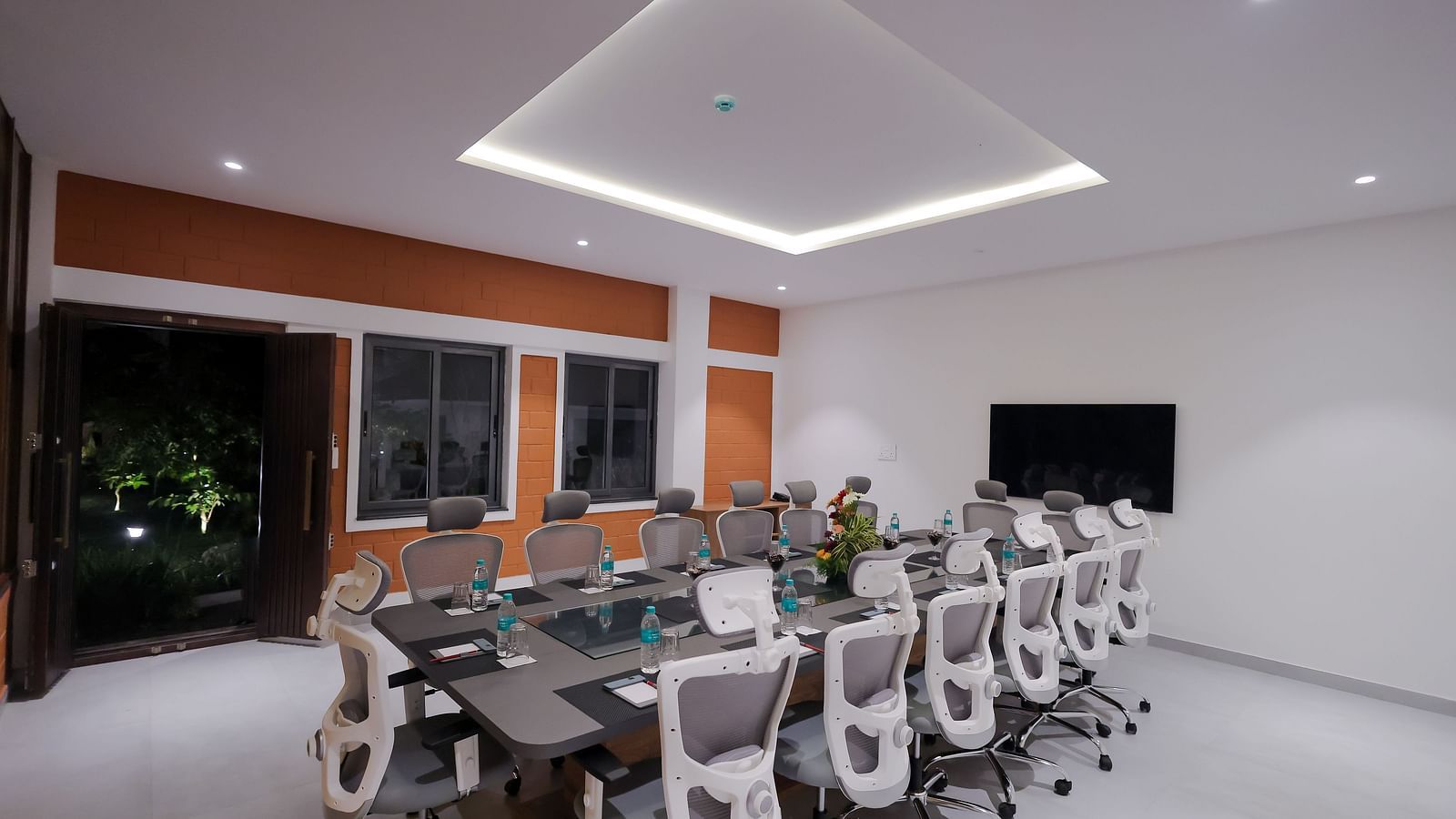 Boardroom with glass window at Trishvam Symphony, Krishnagiri, offering a modern ambience and a collaborative setting.