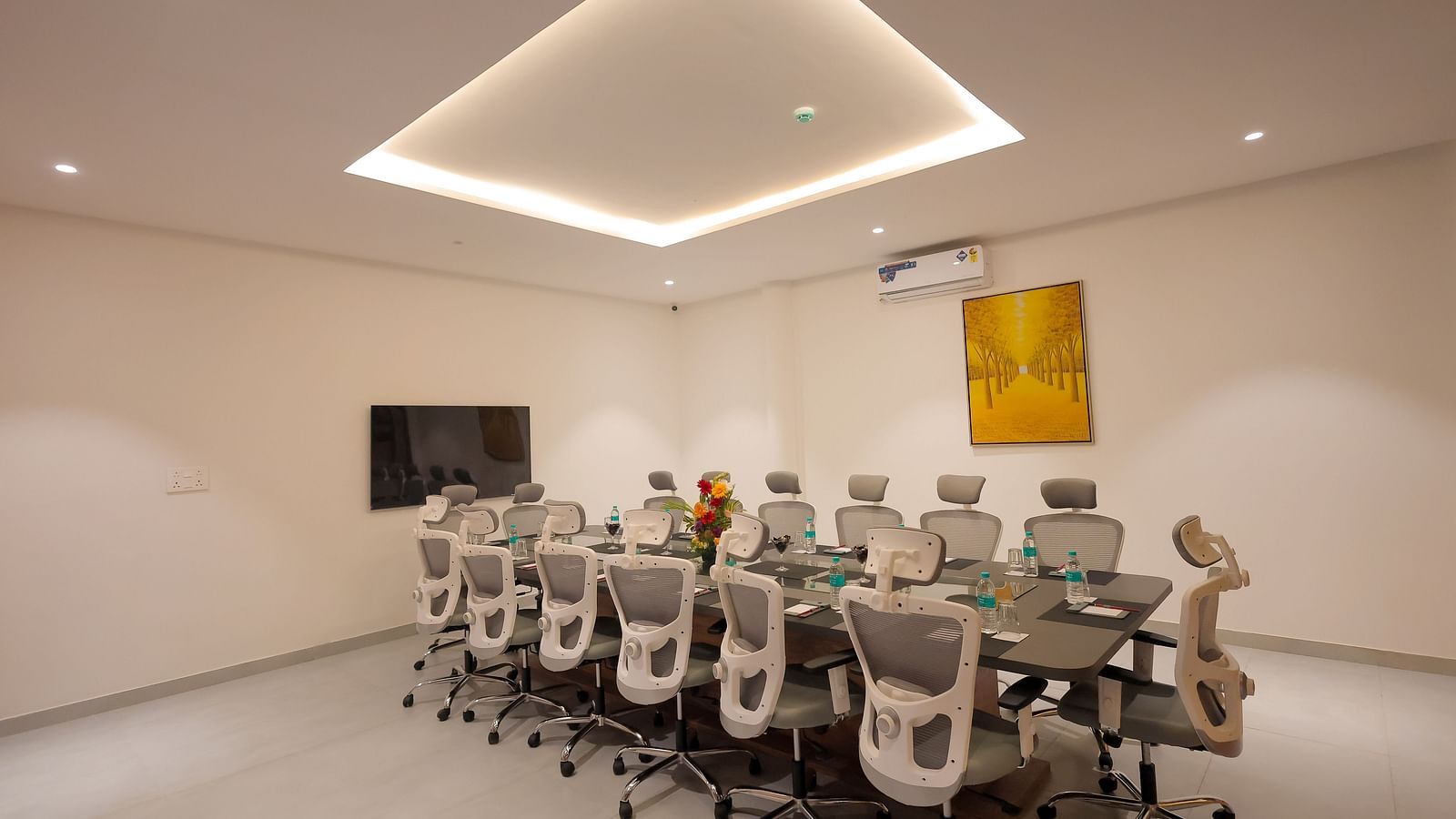 Boardroom at Trishvam Symphony, Krishnagiri, featuring a sleek long table, ergonomic chairs, and a professional meeting environment.