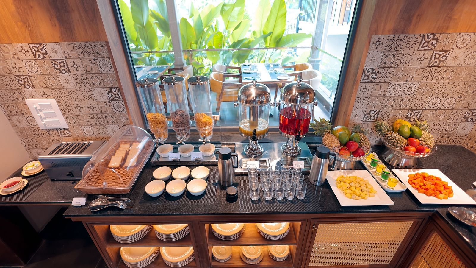 Breakfast buffet setup at Trishvam Symphony, Krishnagiri, offering a variety of dishes in a warm and inviting dining area.