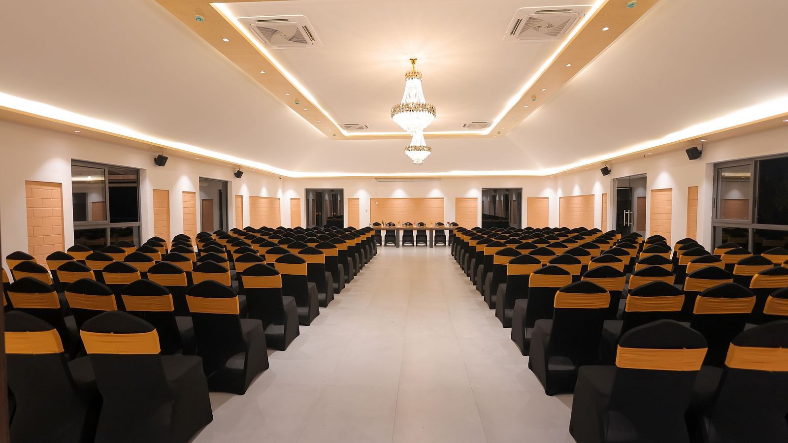 Another view of the main conference hall at Trishvam Symphony, Krishnagiri, with symmetrical lighting and ample seating capacity.